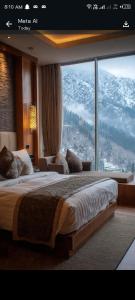 a bedroom with a large bed and a large window at Hotel Marhaba in in Murree