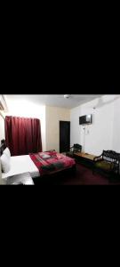 a hotel room with a bed and a flat screen tv at Hotel Marhaba in in Murree