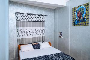 a bedroom with a bed and a painting on the wall at Hôtel Merveille Lomé in Lomé +66 photos