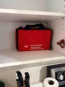 a red suitcase sitting on a shelf in a closet at Olas Place in Regina