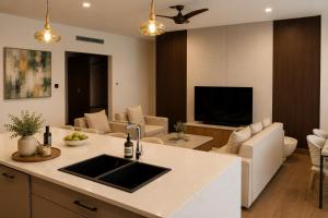 a kitchen and living room with a sink and a tv at Bluezone Club Residences by A'ila Resorts in Rodney Bay Village