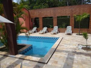 a swimming pool with lounge chairs next to a house at Pousada da Mantiqueira in Visconde De Maua