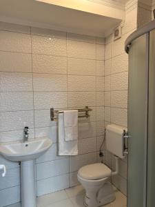 a bathroom with a white toilet and a sink at Duplex in Kosovo Polje