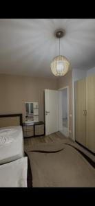 a bedroom with a bed and a television and a chandelier at Duplex in Kosovo Polje