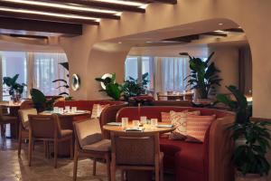 a restaurant with red couches and tables and plants at Andaz Miami Beach Resort & Spa in Miami Beach