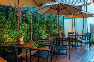 a restaurant with tables and chairs and umbrellas at Holiday Inn Belo Horizonte Savassi by IHG in Belo Horizonte