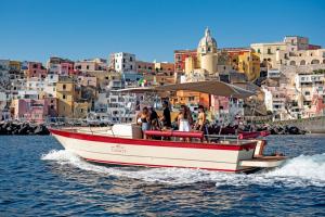 a red and white boat in the water with buildings at Antana Guest House in Procida
