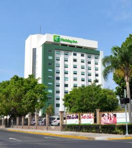 a green and white building with a sign on it at Holiday Inn Guadalajara Expo Plaza del Sol by IHG in Guadalajara