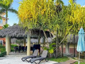 a resort with chairs and a table and a palm tree at Ocean One - Harmony! in Cabarete