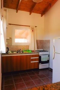 a kitchen with a stove and a sink at Cabañas Entre Campos in Los Reartes