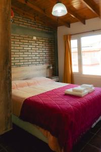 a bedroom with a bed with two towels on it at Cabañas Entre Campos in Los Reartes