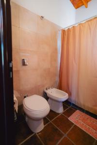 a bathroom with a toilet and a sink at Cabañas Entre Campos in Los Reartes