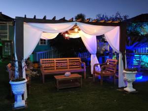 a gazebo with a bench in a yard at night at Pousada Paraíso do Atlântico in Arraial do Cabo