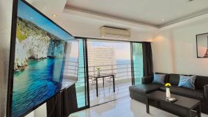 a living room with a large screen tv and a couch at Beautiful Sea View Cozy Condo in Pattaya South