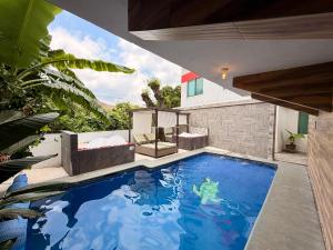 a swimming pool in the middle of a house at Loft Lujo Estilo y Diseño, alberca con calefacción! Cuernavaca somos los únicos en ofrecerte 2 jacuzzis tipo Spa con agua caliente y sistema de hidromasaje, elegante y amplia cama de alberca, 3 Smart TV, terraza privada con asador de carbon, WiFi gratis! in Cuernavaca