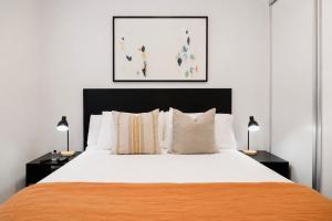 a bedroom with a large bed with two lamps at Punthill Ivanhoe in Melbourne