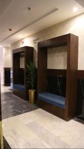 an empty lobby with a large wall with a plant at Areen Almatar Serviced Apartments شقق ارين المطار للشقق المخدومة in Jeddah +73 photos