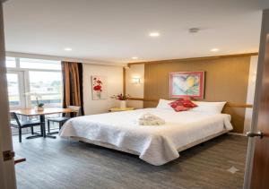 a hotel room with a large bed and a table at The Grand Wanganui in Whanganui