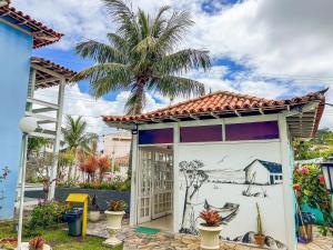 a mural on the side of a building with a palm tree at Pousada Paraíso do Atlântico in Arraial do Cabo