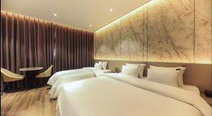 a hotel room with two beds and a table at Hotel RIL in Gwangju