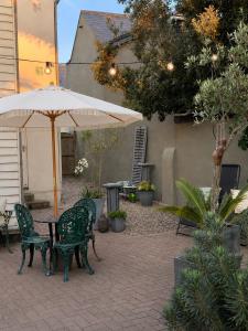 a patio with a table and chairs and an umbrella at Copeland House 4 Island Wall in Whitstable