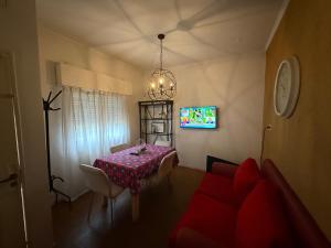 a dining room with a table and a tv at casa Muñiz in Muñiz +18 photos
