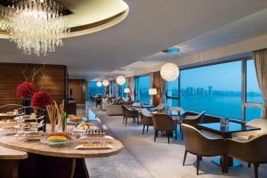 a restaurant with tables and chairs and a view of the water at Marco Polo Wuhan in Wuhan
