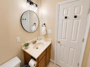 a bathroom with a sink and a mirror at Spacious 3BR Retreat Perfect for Groups Near Downtown in Raleigh +23 photos