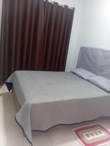 a bed in a room with a brown curtain at Pousada Do Goiano in Manhã