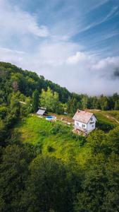 a small white house in a grassy field at Vila Sekvoja in Nova Varoš