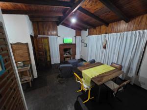 a dining room with a wooden table and chairs at El Refugio Misiones in Garupá +2 photos