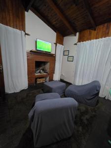 a room with three beds and a flat screen tv at El Refugio Misiones in Garupá