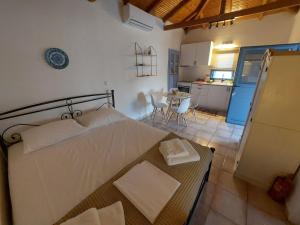 a bedroom with a bed and a kitchen with a table at Marialena's houses in Methoni