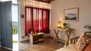 a living room with a red curtain and a table at Le Refuge in McLeod Ganj