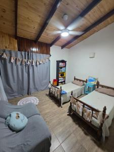 a living room with two beds and a couch at El Refugio Misiones in Garupá