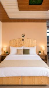 a bedroom with a large bed with white pillows at Le Refuge in McLeod Ganj