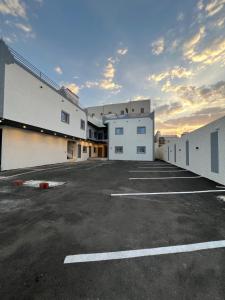a parking lot with white buildings and a cloudy sky at شقق فاخرة in Mahlal