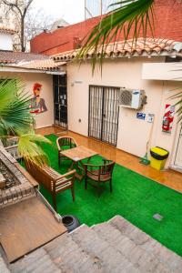 a backyard with green grass and a table and chairs at Pulkay Hostel Folk in Mendoza +20 photos