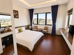 a hotel room with a bed and a tv at Saffron Boutique Hotel in Da Lat