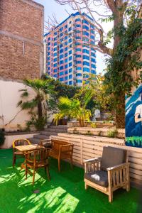a patio with a table and chairs and a building at Pulkay Hostel Folk in Mendoza