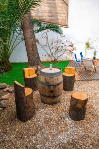 a barrel and chairs and a table and a tree at Pulkay Hostel Folk in Mendoza