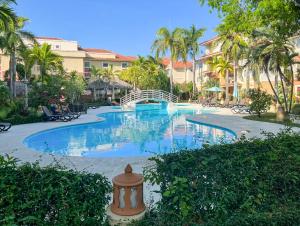 a large swimming pool in a resort with palm trees at Ocean One - Harmony! in Cabarete