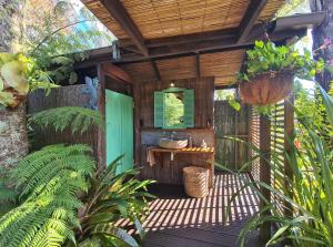 an outdoor bathroom with a sink and a table at Bali Haven in Coromandel Town +20 photos