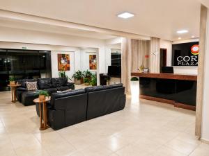 a lobby with black leather couches and a bar at Corumbá Plaza Hotel in Luziânia