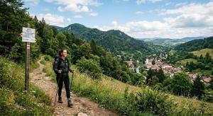 a woman standing on a hill next to a sign at Chata u Emi a Ivana in Tajov