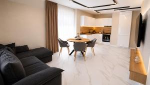 a living room with a couch and a table and chairs at Nikol River Residence in Sandanski