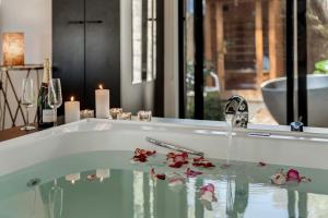 a bathroom with a bath tub with flowers in it at Istana Indulge in Hepburn Springs