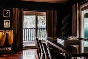 a dining room with a table and chairs and a balcony at Istana Lodge in Musk Vale