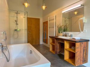 a bathroom with a tub and a sink and a mirror at Bellone 52 in Lake Pressegg +54 photos