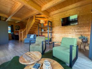 a living room with chairs and a tv on a wooden wall at Rattendorf 23A in Rattendorf